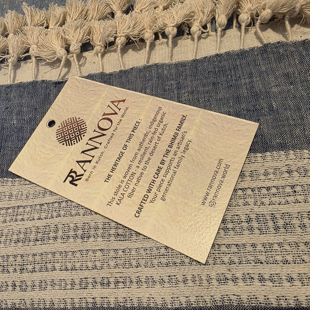 Rannova hangtag resting on an indigo Kala cotton stole