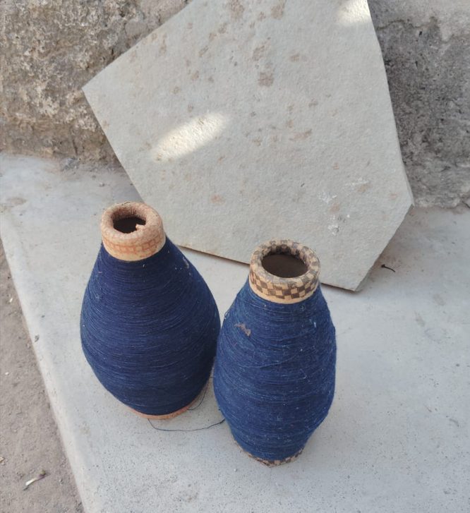 Indigo-dyed cotton yarn on spools